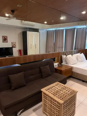 a living room with a couch and a bed at Cozi Makati Executive Studio balcony in Manila