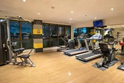 a gym with several treadmills and exercise equipment at Cozi Makati Executive Studio balcony in Manila