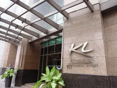 a building with a sign on the side of it at Cozi Makati Executive Studio balcony in Manila