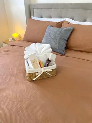 a basket of towels and towels on a bed at The Hive Staycation - SMDC Hope Residences in Trece Martires