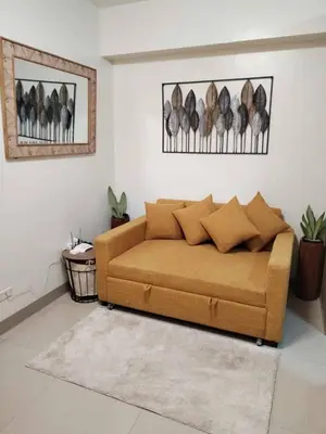 a living room with a brown couch in a room at Shore Residence Tower III in Manila