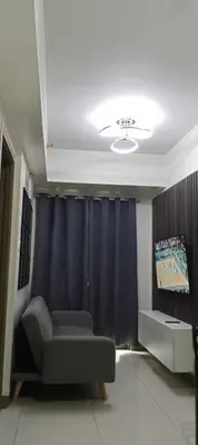 a living room with a couch and a blue curtain at S-Residence Staycation IKEA,MOA,PICC in Manila
