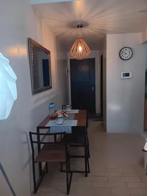 a dining room with a table and chairs and a clock at M&N Condotel in Manila