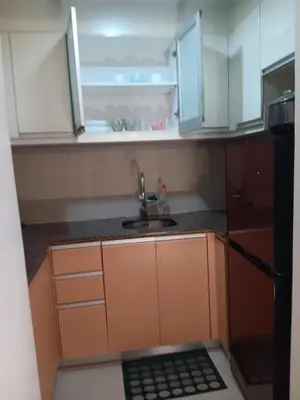 a small kitchen with a sink and a refrigerator at M&N Condotel in Manila