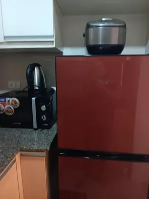 a kitchen with a red refrigerator and a microwave at M&N Condotel in Manila