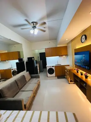 a living room with a couch and a tv at Unit 23L T-B The Pearl Place Ortigas in Manila