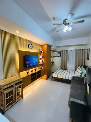 a living room with a couch and a tv at Unit 23L T-B The Pearl Place Ortigas in Manila
