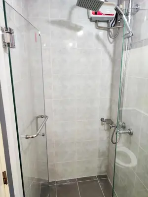 a shower stall with a glass door with a shower at Unit 23L T-B The Pearl Place Ortigas in Manila