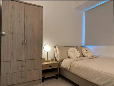 a bedroom with a large wooden cabinet and a bed at Cityscape Suite in Manila