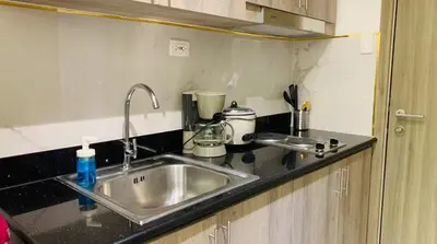 a kitchen counter with a sink and a appliance at Cityscape Suite in Manila