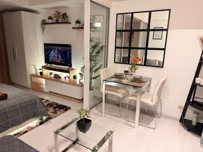 a living room with a table and a television in it at Azure Urban Resort-The Rustic Escape in Manila
