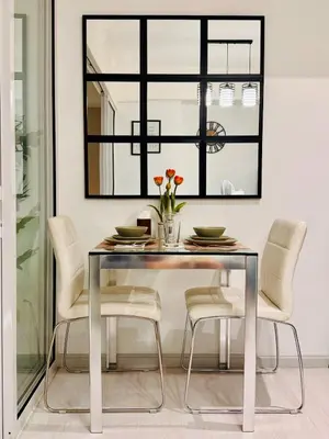 a dining room table with white chairs and a mirror at Azure Urban Resort-The Rustic Escape in Manila