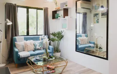 a living room with a blue couch and a mirror at Modern Chic Retreat in Antipolo