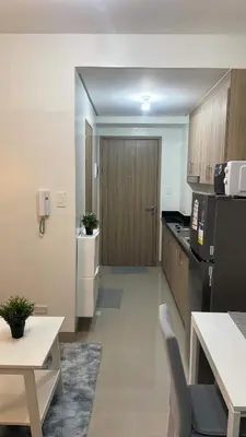 a kitchen with a refrigerator and a table with chairs at Shore 2 Tower 3 1BR 15th Floor Near SMX MOA in Manila