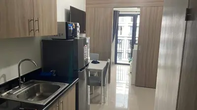 a kitchen with a sink and a refrigerator at Shore 2 Tower 3 1BR 15th Floor Near SMX MOA in Manila