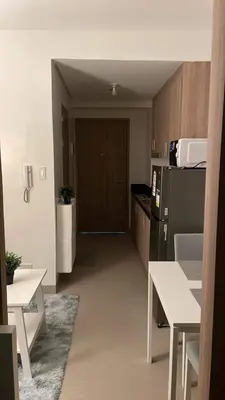 a room with a kitchen with a refrigerator and a table at Shore 2 Tower 3 1BR 15th Floor Near SMX MOA in Manila