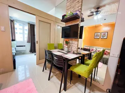 a dining room with a table and green chairs at RE Staycations in Manila