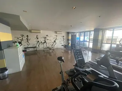 a gym with treadmills and exercise bikes in a room at KL Tower Cosy Studio with City and Park View in Manila