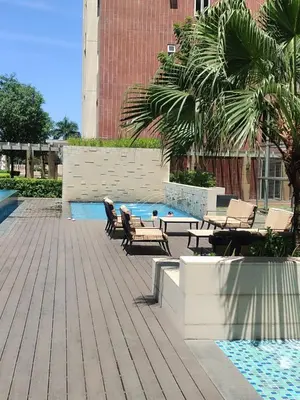 a patio with chairs and a pool in a building at BS651 Room with Balcony and free pool in Manila