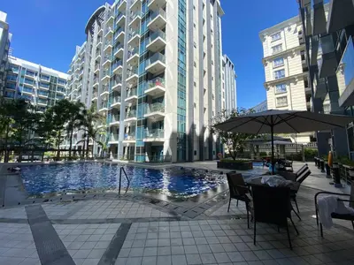 a table with an umbrella next to a large building at the palm tree villas by kath in Manila