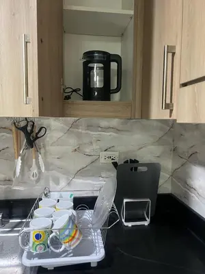 a kitchen counter with a tray of dishes and a coffee pot at 2Br Suite Shore Residences by JMS in Manila