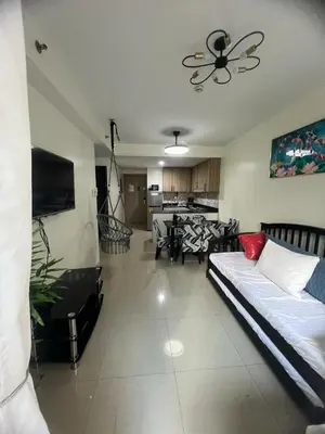a living room with a couch and a ceiling fan at 2Br Suite Shore Residences by JMS in Manila