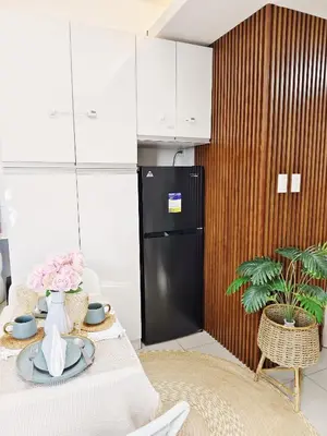 a kitchen with a table with a black refrigerator at Affordable Staycation in Dasma Green 2 Residence in Dasmariñas