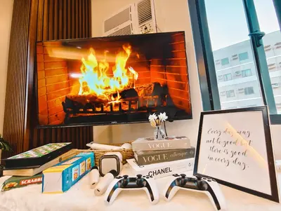 a table with books and a fireplace in a room at Affordable Staycation in Dasma Green 2 Residence in Dasmariñas