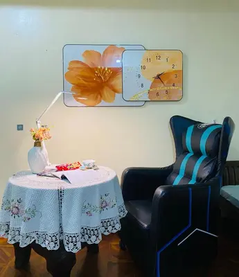 a table with a chair and a clock on the wall at He Condotel Bell in Manila