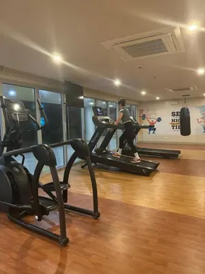 a woman running on a treadmill in a gym at Panoramic Landscape and Seaview, 2BR, Near Airport, 8m in Manila
