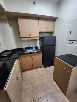 a kitchen with a sink and a black refrigerator at 2BR Condo near BGC in Manila