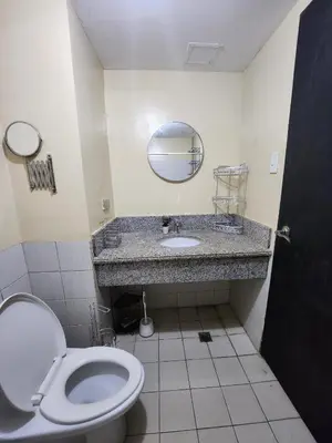 a bathroom with a toilet and a sink at 2BR Condo near BGC in Manila
