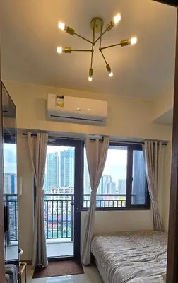 a bedroom with a bed and a large window at SMDC Red Residences Makati w own parking slot in Manila