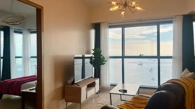 a living room with a large window with a view at 3BR Grand Riviera Suites by MrSayla in Manila