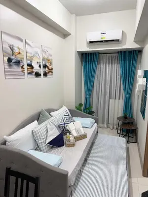 a living room with a couch and a tv at Clarquin Residences - Shore 3 Residences Tower 2 in Manila