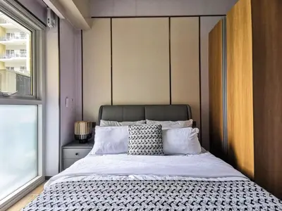 a bedroom with a large bed and a window at Bayshore Staycation in Manila