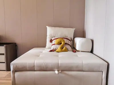 a white bed with a stuffed yellow duck on it at Bayshore Staycation in Manila