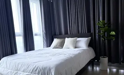 a bed with white sheets and pillows in a bedroom at Spacious Modern Suites with Amazing City View in Manila