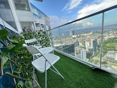a balcony with two chairs and a view of a city at Spacious Modern Suites with Amazing City View in Manila