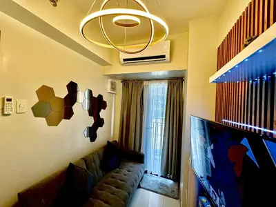 a living room with a couch and a tv at Shore 3 Residences - HTZ Haven in Manila