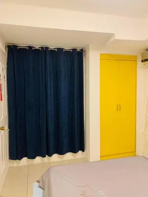 a bedroom with a blue curtain and a yellow door at He Condotel Blessed in Manila