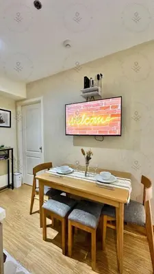 a dining room with a wooden table and chairs at 2BR condo Azure Netflix, Karaoke & Board games in Manila