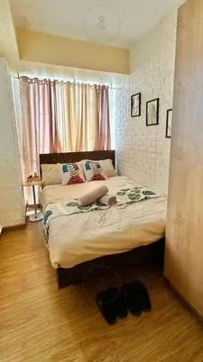 a bedroom with a large bed with shoes on the floor at 2BR condo Azure Netflix, Karaoke & Board games in Manila