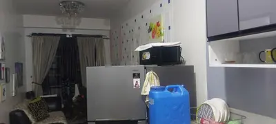 a kitchen with a refrigerator and a tv on top of it at Florida sun condo in Dasmariñas