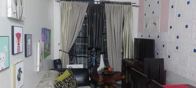 a living room with a chair and a window at Florida sun condo in Dasmariñas