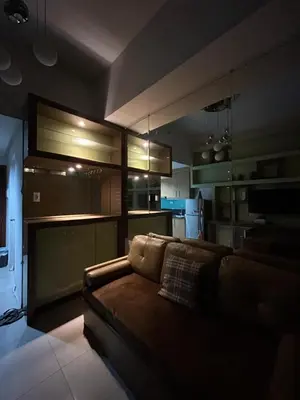 a living room with a couch and a kitchen at Deluxe Room Pool View in Mall of Asia Pasay Near Airport in Manila