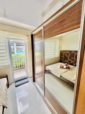 a small room with a bed and a window at Deluxe Room Pool View in Mall of Asia Pasay Near Airport in Manila