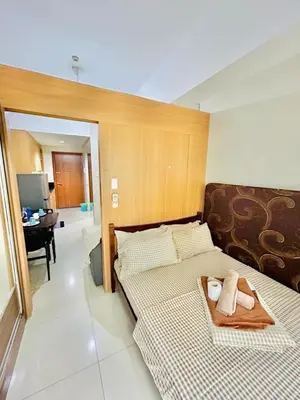 a bedroom with two beds and a desk in a room at Deluxe Room Pool View in Mall of Asia Pasay Near Airport in Manila