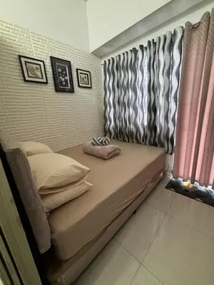 a small bed in a room with a window at AZs Staycation in Manila