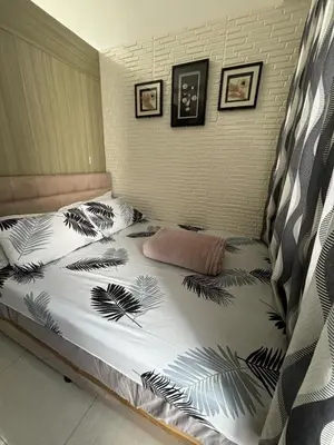 a bedroom with a bed with a black and white comforter at AZs Staycation in Manila